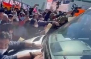 AMLO sale de evento en Tijuana entre protestas, apoyo y hasta un hombre que acostó en el cofre del auto presidencial